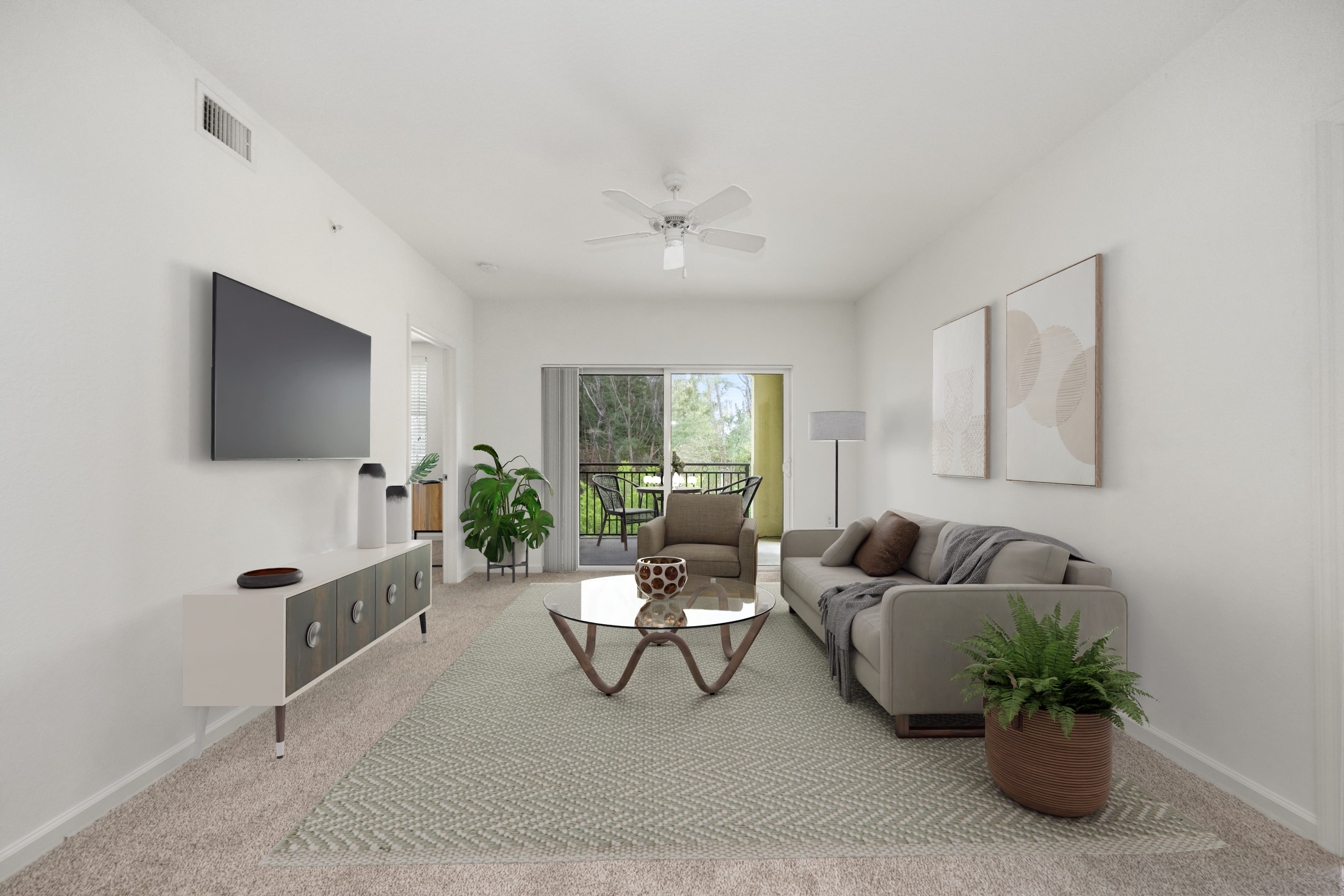 A living room with a grey sofa, a coffee table, and a flat screen TV mounted on the wall.